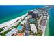 Aerial view showcasing condos, pool, tennis courts, and the pristine beaches of Treasure Island, Florida at 7564 Bayshore Dr # 302, Treasure Island, FL 33706