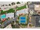 Aerial view of a community featuring two swimming pools, tennis courts, lush landscaping, and beachfront access at 7564 Bayshore Dr # 302, Treasure Island, FL 33706