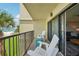 Balcony with seating offering tranquil views of the ocean and lush tropical foliage at 7564 Bayshore Dr # 302, Treasure Island, FL 33706