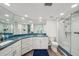 Well-lit bathroom featuring blue granite counters, dual sinks, and a glass-enclosed shower at 7564 Bayshore Dr # 302, Treasure Island, FL 33706