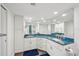 Well-lit bathroom showcasing blue granite counters, dual sinks, and ample cabinet space at 7564 Bayshore Dr # 302, Treasure Island, FL 33706
