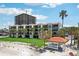 Beautiful condo building with palm trees, a gazebo, and an expansive green lawn at 7564 Bayshore Dr # 302, Treasure Island, FL 33706