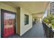 Outdoor hallway with neutral stucco, secure black metal railing, and a view of the blue sky and palm trees at 7564 Bayshore Dr # 302, Treasure Island, FL 33706