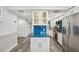 Modern kitchen with an island featuring blue countertop and white cabinets with stainless steel appliances at 7564 Bayshore Dr # 302, Treasure Island, FL 33706