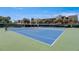 Well-maintained blue tennis courts surrounded by tropical landscaping at 7564 Bayshore Dr # 302, Treasure Island, FL 33706