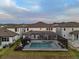 Aerial view of home with screened pool and spa in an attractive backyard setting at 7819 Notched Pine Bnd, Wesley Chapel, FL 33545
