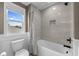 Clean bathroom features a bathtub with shower and a window with backyard views at 7819 Notched Pine Bnd, Wesley Chapel, FL 33545