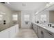 Bright bathroom with large shower, double vanity, and grey cabinets offers a clean, modern design at 7819 Notched Pine Bnd, Wesley Chapel, FL 33545