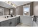 Modern bathroom featuring a double vanity with quartz countertops and a large mirror at 7819 Notched Pine Bnd, Wesley Chapel, FL 33545