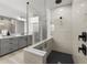 Modern bathroom with sleek glass shower, black fixtures, and gray vanity offers contemporary elegance at 7819 Notched Pine Bnd, Wesley Chapel, FL 33545