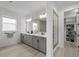 Luxurious bathroom featuring double vanity, large mirror, and access to a walk-in closet at 7819 Notched Pine Bnd, Wesley Chapel, FL 33545