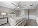 Comfortable bedroom featuring a large bed with a padded headboard and a stylish ceiling fan at 7819 Notched Pine Bnd, Wesley Chapel, FL 33545