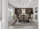 Elegant dining room with coffered ceilings, wainscoting, and modern chandelier at 7819 Notched Pine Bnd, Wesley Chapel, FL 33545