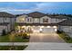 Elegant two-story home featuring a paved driveway and a welcoming front porch with cozy seating at 7819 Notched Pine Bnd, Wesley Chapel, FL 33545