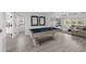 Open game room with a pool table and ample seating offers space for entertainment and relaxation at 7819 Notched Pine Bnd, Wesley Chapel, FL 33545