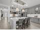 Bright, open kitchen with gray cabinets, quartz countertops, and a large center island with seating at 7819 Notched Pine Bnd, Wesley Chapel, FL 33545