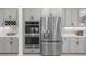 A chef's kitchen with built-in stainless steel appliances and sleek gray cabinetry at 7819 Notched Pine Bnd, Wesley Chapel, FL 33545