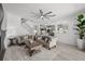 Bright living room with an open layout, ceiling fan, and view of the kitchen at 7819 Notched Pine Bnd, Wesley Chapel, FL 33545