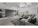 Comfortable living room with a large screen and coffered ceiling provides a cozy and stylish atmosphere at 7819 Notched Pine Bnd, Wesley Chapel, FL 33545