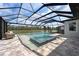 A tranquil screened pool and spa offers serene views of the water at 7819 Notched Pine Bnd, Wesley Chapel, FL 33545