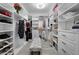 Spacious walk-in closet features custom shelving and a central seating bench for organization and convenience at 7819 Notched Pine Bnd, Wesley Chapel, FL 33545