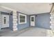 View of covered and gated entrance with white trim and classic wall lamps at 8006 Tanglewood Ln, Tampa, FL 33615