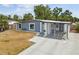 Charming home exterior showcasing a landscaped front yard, driveway, and decorative gated entry at 8006 Tanglewood Ln, Tampa, FL 33615