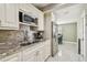 Well-equipped kitchen showcasing stainless steel appliances, granite countertops, and tiled backsplash at 8006 Tanglewood Ln, Tampa, FL 33615