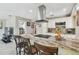 Kitchen island featuring granite countertops, stainless steel vent hood and barstool seating at 8006 Tanglewood Ln, Tampa, FL 33615