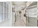 Galley kitchen featuring stainless steel refrigerator, granite countertops, and white cabinetry at 8006 Tanglewood Ln, Tampa, FL 33615