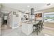 Bright kitchen with stainless steel appliances, island with barstool seating, and sleek tile flooring at 8006 Tanglewood Ln, Tampa, FL 33615