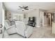 Inviting living room with comfortable reclining seating, tile floors, ceiling fan, and a large television at 8006 Tanglewood Ln, Tampa, FL 33615
