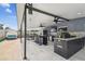 Outdoor kitchen with stone accents, granite countertops, stainless steel appliances, and ceiling fans for comfortable outdoor dining at 8006 Tanglewood Ln, Tampa, FL 33615