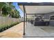 Extended outdoor kitchen area with barstools for seating and landscaping in a fenced yard at 8006 Tanglewood Ln, Tampa, FL 33615