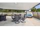 Covered patio features a dining table with six chairs, outdoor seating, and lush landscaping for outdoor relaxation and dining at 8006 Tanglewood Ln, Tampa, FL 33615
