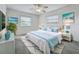 Cozy bedroom features a ceiling fan, two windows, and beachy decor for a tranquil retreat at 904 Desert Hills Dr, Sun City Center, FL 33573