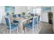 Dining room with white table, seating for six, and beach-themed artwork at 904 Desert Hills Dr, Sun City Center, FL 33573