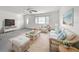 Bright living room featuring wicker furniture, ceiling fan, and beach-themed decor at 904 Desert Hills Dr, Sun City Center, FL 33573