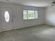 Bright living room with a white door, neutral walls, and lots of natural light at 904 Desert Hills Dr, Sun City Center, FL 33573