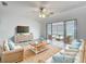 Cozy living room with wicker furniture, sliding glass doors, and a ceiling fan at 904 Desert Hills Dr, Sun City Center, FL 33573