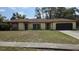 Single-story home featuring a two-car garage and a well-maintained lawn in a sunny neighborhood at 531 Carriage Hills Dr, Temple Terrace, FL 33617
