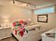 Cozy bedroom featuring soft lighting, floral bedding, and white furniture at 100 Bluff View Dr # 105C, Belleair Bluffs, FL 33770