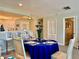 Dining room with white chairs, a blue tablecloth and an open bar space with white cabinetry at 100 Bluff View Dr # 105C, Belleair Bluffs, FL 33770