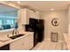 Well-lit kitchen featuring stainless steel appliances, white cabinets, and lovely tile floors at 100 Bluff View Dr # 105C, Belleair Bluffs, FL 33770