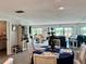 Living room with seating, a bookshelf, a table with floral arrangement, and view to the outside balcony at 100 Bluff View Dr # 105C, Belleair Bluffs, FL 33770