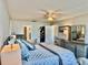 Comfortable main bedroom with ceiling fan, walk-in closet, and dresser with matching mirror at 100 Bluff View Dr # 105C, Belleair Bluffs, FL 33770