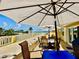 Patio featuring outdoor furniture and shade umbrellas overlooking the bay at 100 Bluff View Dr # 105C, Belleair Bluffs, FL 33770