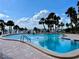Beautiful outdoor swimming pool with palm trees and a view of the bay at 100 Bluff View Dr # 105C, Belleair Bluffs, FL 33770