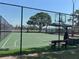 Outdoor basketball court with a green surface, hoops, and a bench, all enclosed by a chain-link fence at 10807 Candle Stick Ln, Riverview, FL 33579