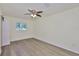 Bright bedroom features wood flooring, a ceiling fan, and natural light from a window at 10922 Park Dr, Riverview, FL 33569
